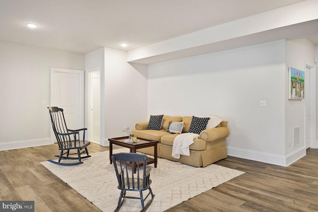 living room with baseboards, visible vents, wood finished floors, and recessed lighting