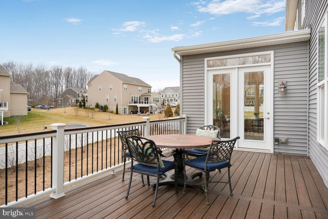 wooden terrace featuring outdoor dining space and a residential view