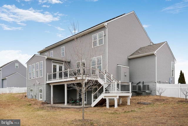 rear view of house featuring a deck, a patio, central AC, fence, and stairway