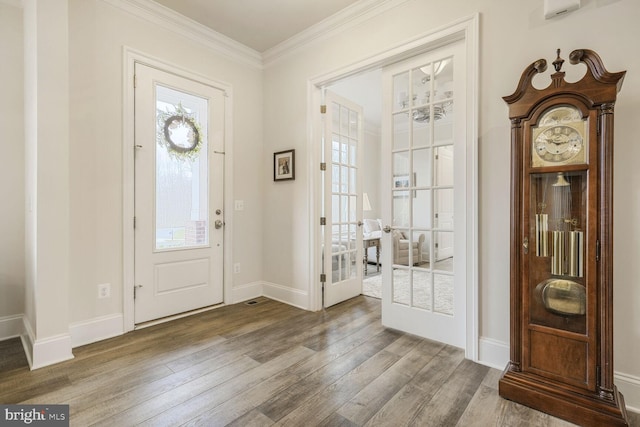 entrance foyer featuring crown molding, baseboards, wood finished floors, and a healthy amount of sunlight