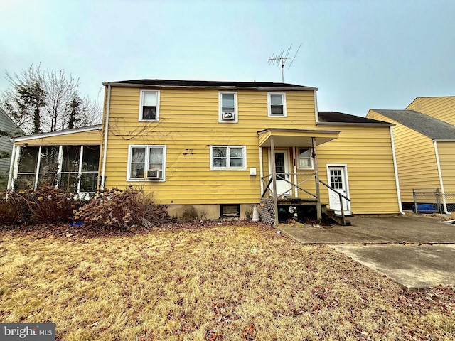 rear view of house featuring a sunroom