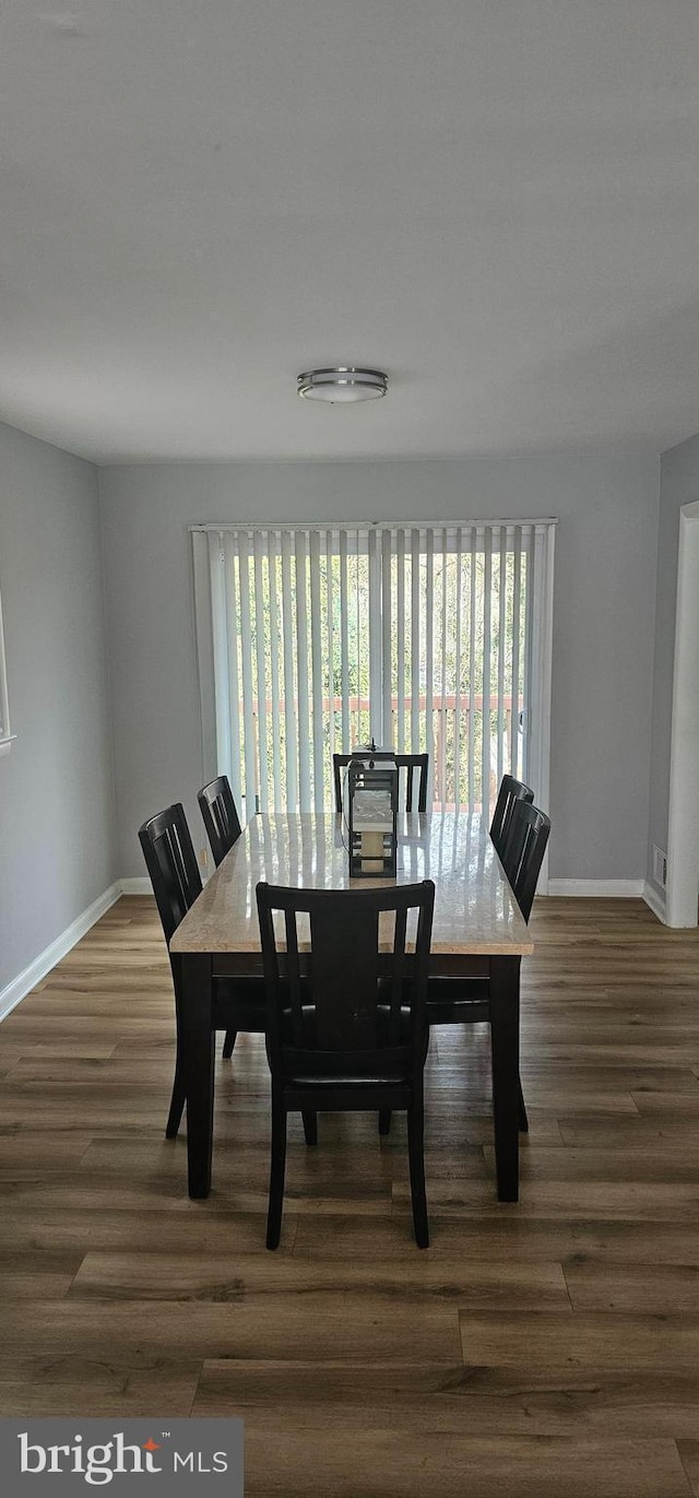 dining space featuring dark wood finished floors and baseboards