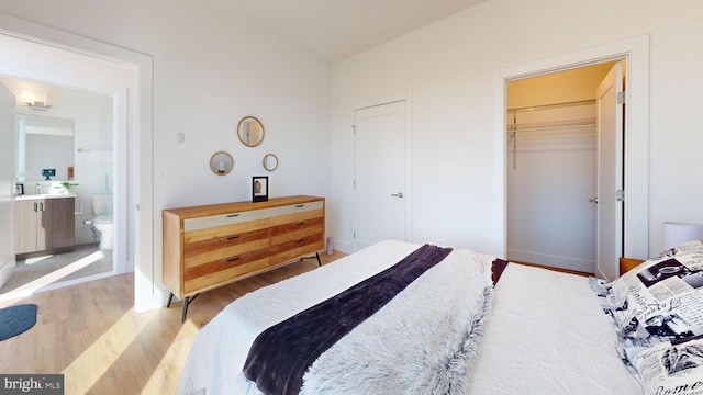 bedroom with light wood-style floors, baseboards, and a closet