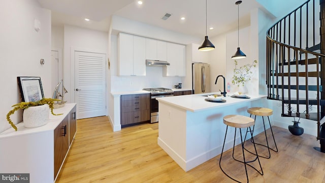 kitchen featuring a kitchen bar, modern cabinets, visible vents, and stainless steel appliances