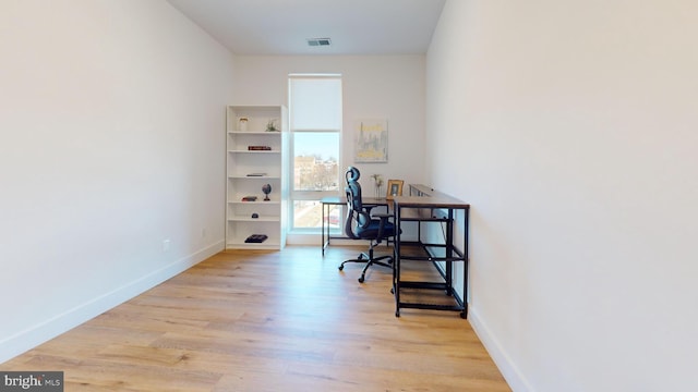 home office with visible vents, light wood-style floors, and baseboards