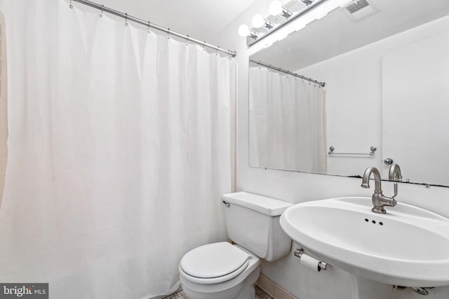 bathroom with a sink, visible vents, curtained shower, and toilet