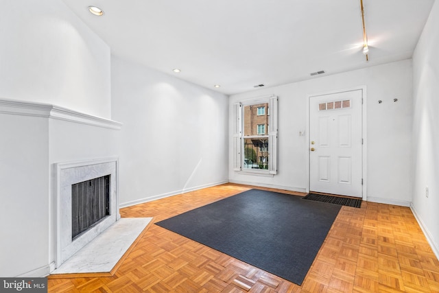 entryway featuring recessed lighting, a fireplace, visible vents, and baseboards