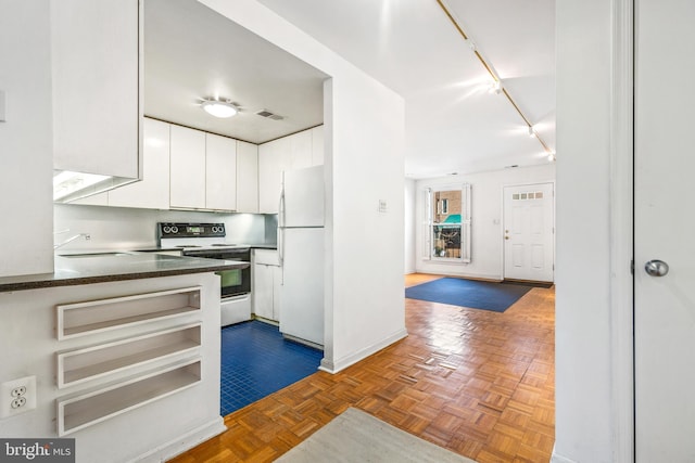 kitchen with visible vents, freestanding refrigerator, electric stove, rail lighting, and white cabinetry