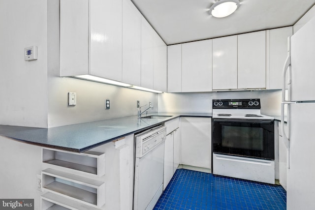 kitchen with white appliances, a peninsula, a sink, tile patterned flooring, and white cabinetry