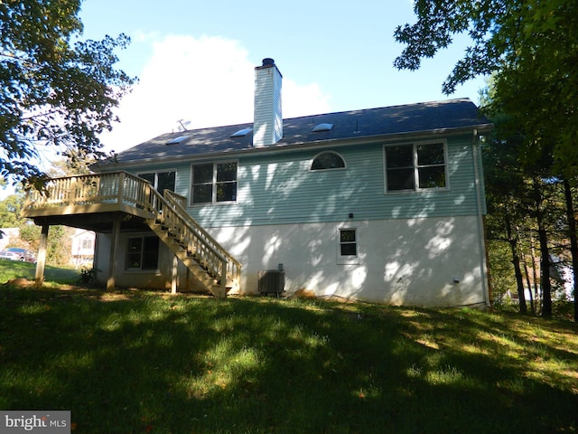 back of house featuring a yard, a chimney, central AC, a wooden deck, and stairs