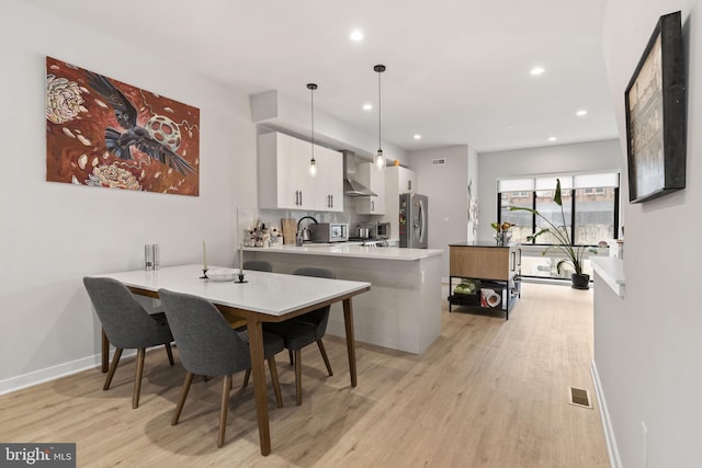 dining room featuring recessed lighting, light wood-type flooring, baseboards, and visible vents