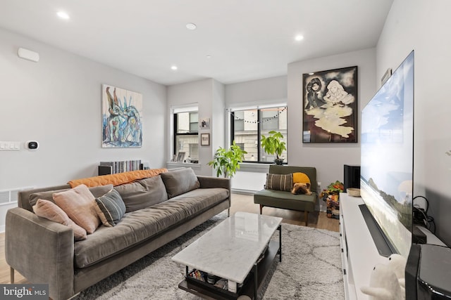 living area with recessed lighting, visible vents, and light wood-style floors