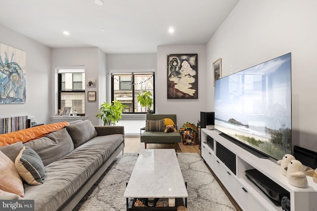 living area featuring light wood finished floors, recessed lighting, and a healthy amount of sunlight