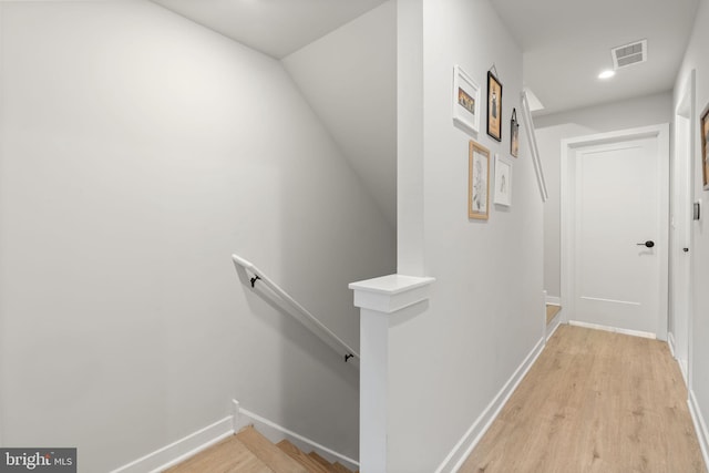 corridor featuring visible vents, baseboards, an upstairs landing, recessed lighting, and light wood-style floors