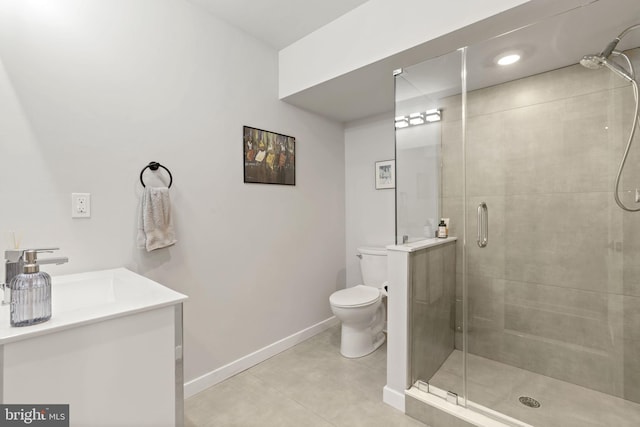 bathroom with a stall shower, toilet, vanity, and baseboards