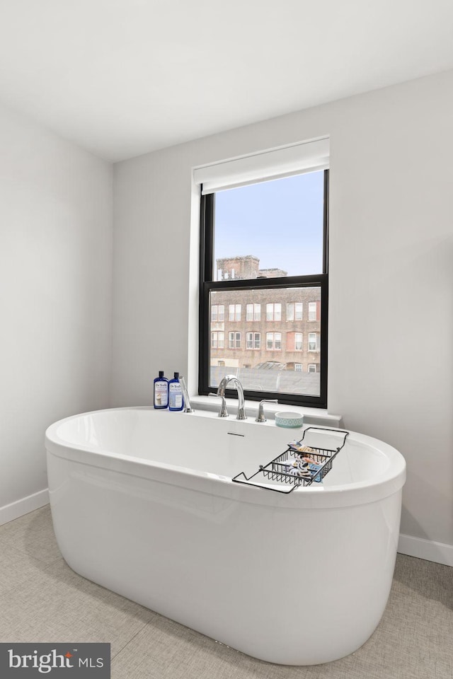 bathroom with baseboards and a freestanding bath