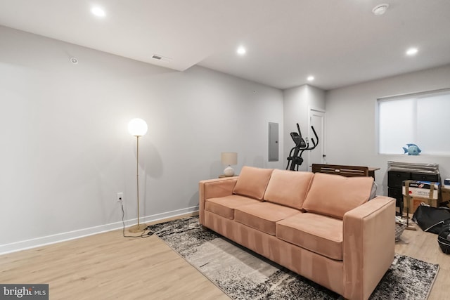 living room featuring visible vents, electric panel, recessed lighting, light wood-style floors, and baseboards