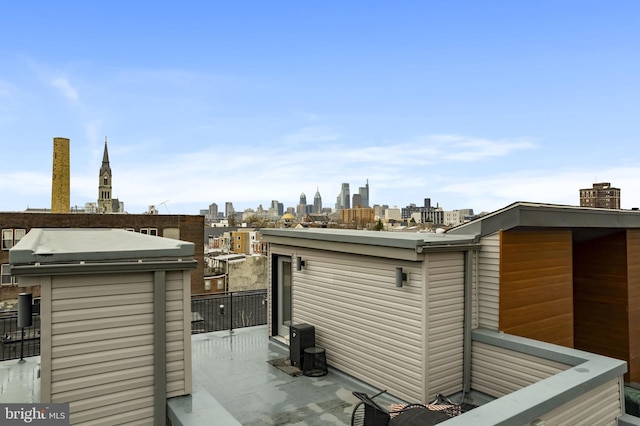 exterior space with a view of city, a balcony, and a chimney