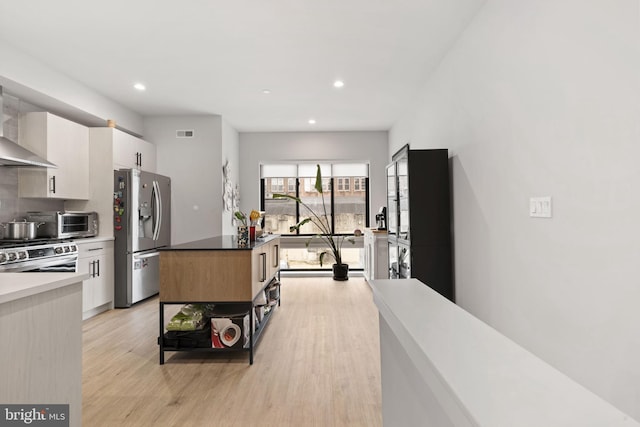 kitchen with white cabinetry, recessed lighting, light wood-type flooring, and stainless steel appliances