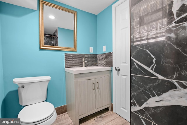 bathroom featuring toilet, wood finished floors, and vanity