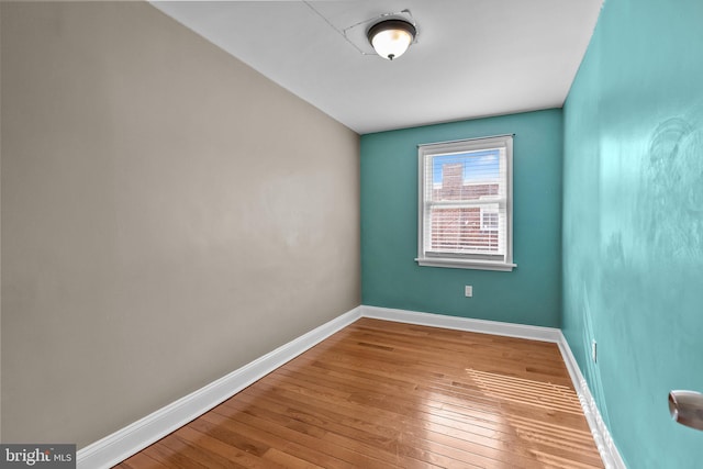 empty room featuring hardwood / wood-style floors and baseboards