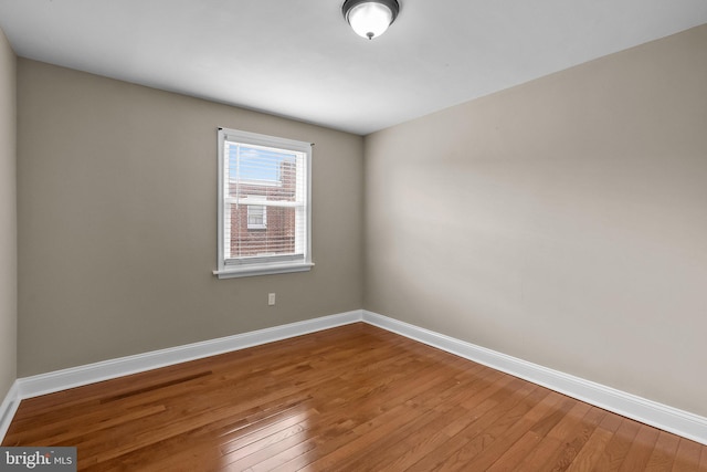 unfurnished room with wood-type flooring and baseboards