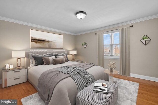 bedroom with crown molding, light wood-style flooring, and baseboards