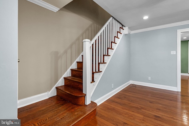 stairs featuring ornamental molding, wood finished floors, and baseboards