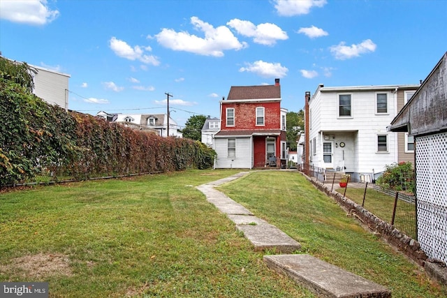 view of front facade featuring a front lawn, fence, brick siding, and a chimney