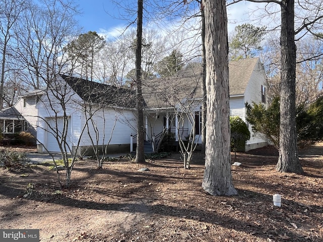 view of side of home with a garage and dirt driveway