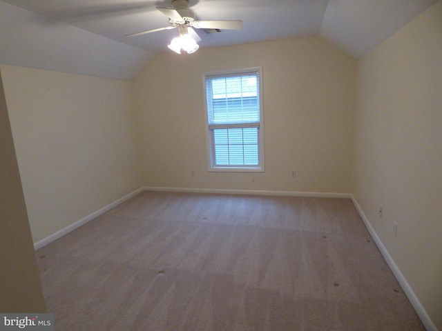 bonus room with a ceiling fan, lofted ceiling, light colored carpet, and baseboards