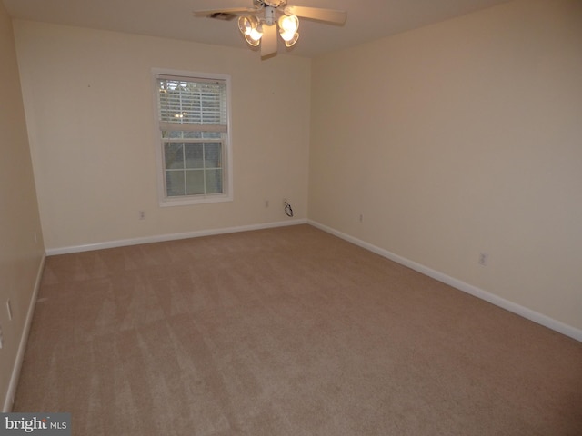 empty room with light carpet, ceiling fan, and baseboards