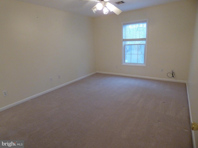 empty room featuring ceiling fan, carpet, and baseboards