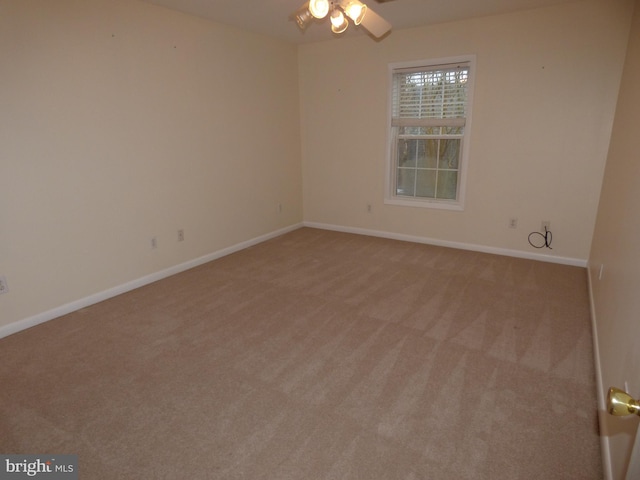 unfurnished room with baseboards, ceiling fan, and light colored carpet