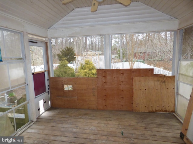 unfurnished sunroom featuring lofted ceiling, wooden ceiling, a ceiling fan, and a healthy amount of sunlight