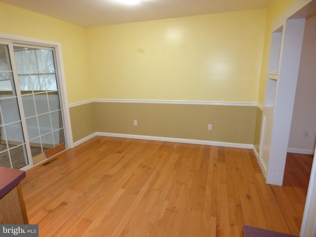 spare room with hardwood / wood-style flooring and baseboards