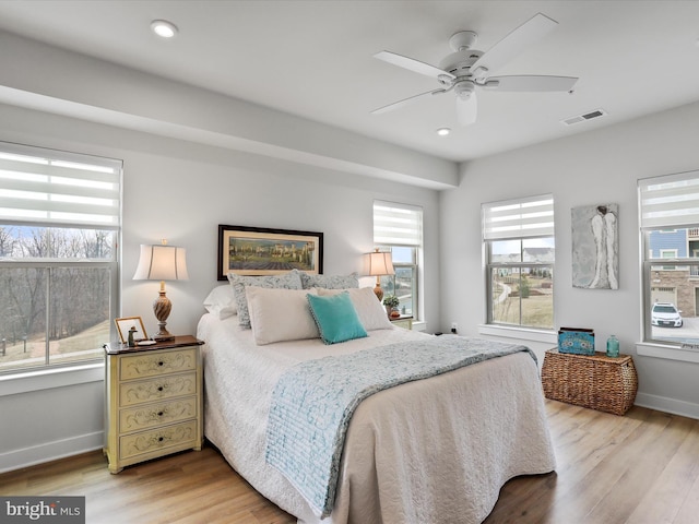 bedroom with light wood finished floors, recessed lighting, visible vents, and baseboards