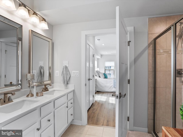 ensuite bathroom featuring a stall shower, a sink, ensuite bath, and tile patterned floors