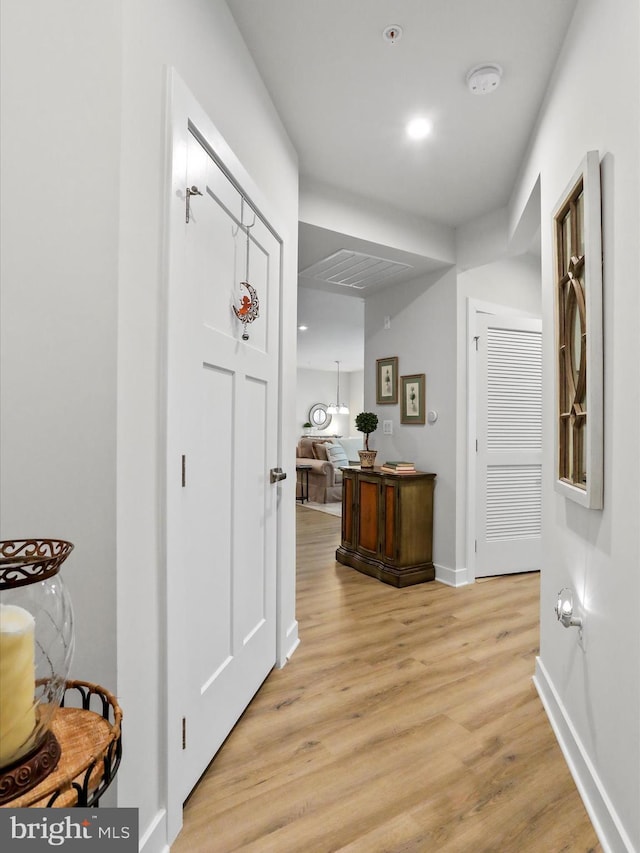 hall featuring light wood-type flooring, baseboards, and recessed lighting