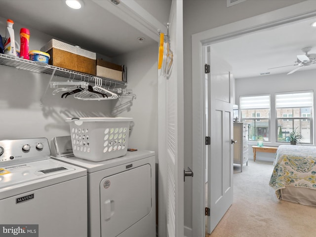 laundry room with a ceiling fan, laundry area, light carpet, and washing machine and clothes dryer