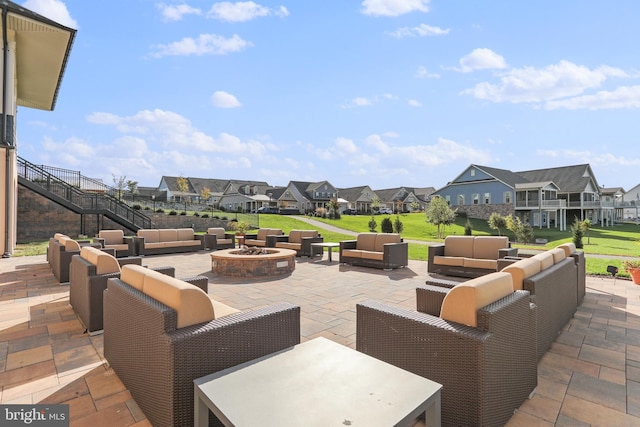 view of patio featuring stairway, an outdoor living space with a fire pit, and a residential view