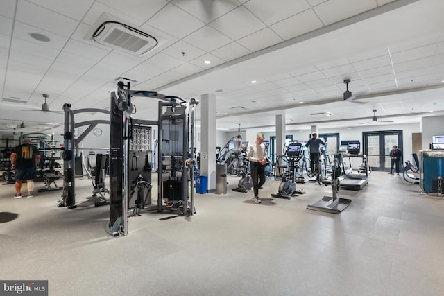 gym with ceiling fan, visible vents, a drop ceiling, and french doors