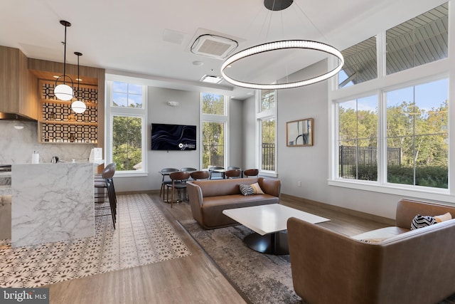 living room with a towering ceiling, wood finished floors, and visible vents