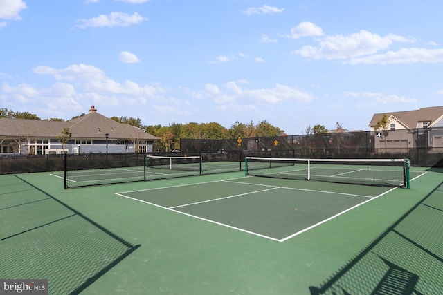 view of tennis court with community basketball court and fence