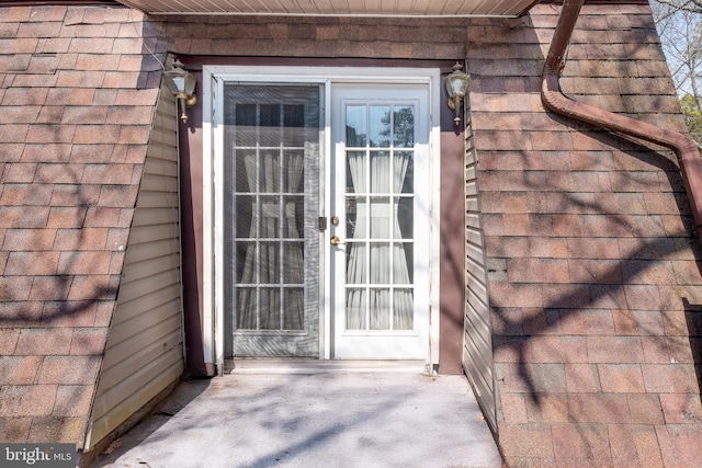 entrance to property featuring a shingled roof