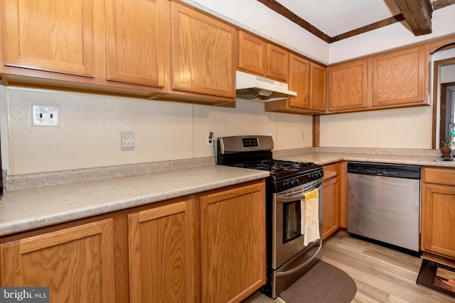 kitchen featuring light countertops, appliances with stainless steel finishes, light wood-style floors, and under cabinet range hood