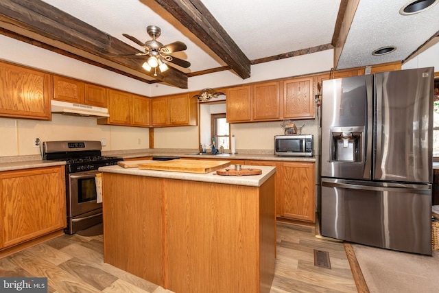 kitchen with under cabinet range hood, visible vents, light countertops, appliances with stainless steel finishes, and a center island