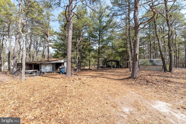 view of yard with a carport and an outdoor structure