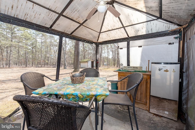 sunroom featuring lofted ceiling and a ceiling fan