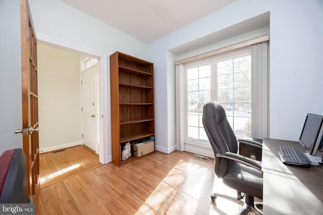 office area featuring visible vents, baseboards, a wealth of natural light, and light wood-style floors